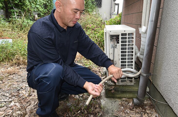 エアコンの水漏れ修理・ドレン調整をしている写真